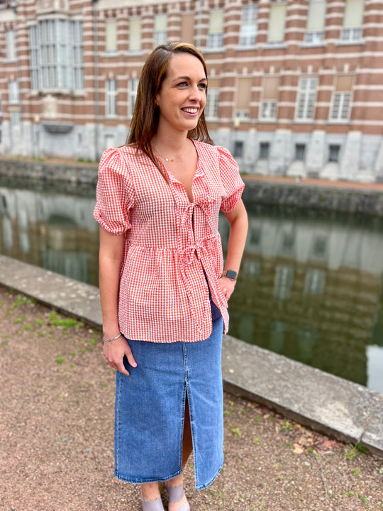 Coral blouse met strikdetails